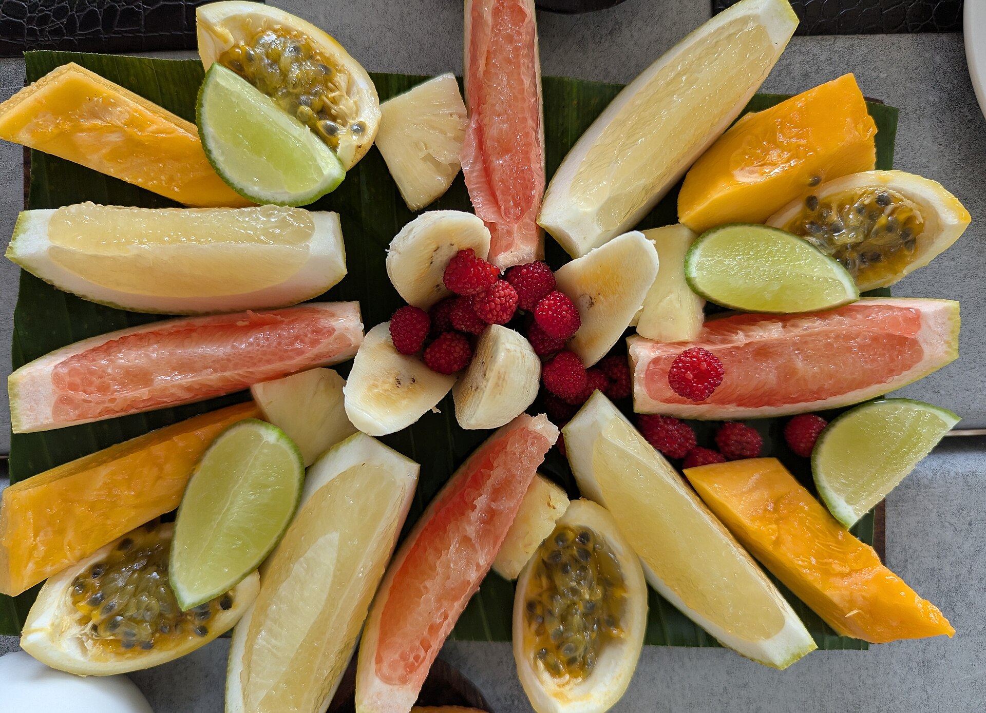 A sunburst fruit platter with melon, oranges and berries