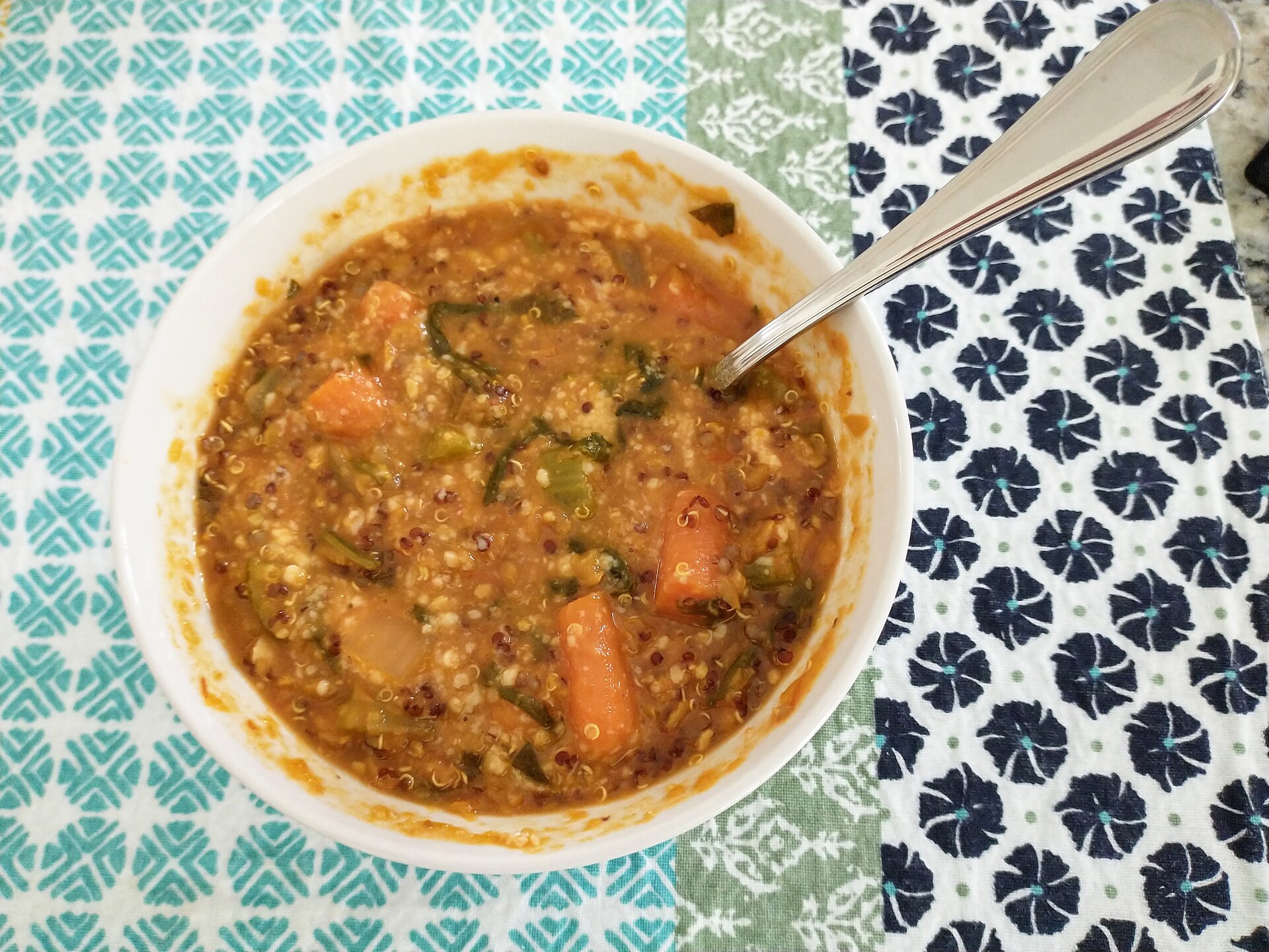 Lentils and carrots in a bowl on a patterned cloth