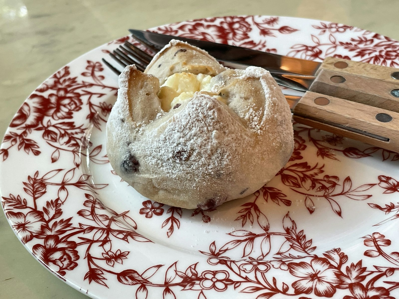 A golden baked pastry on a festive red and white plate