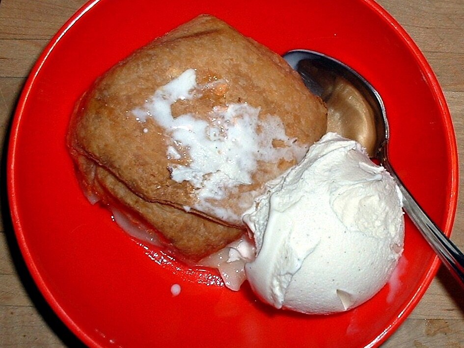 A warm apple dumpling with ice cream