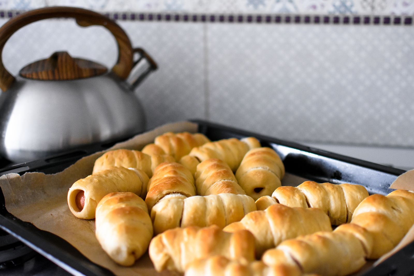 Pigs in a blanket made with crescent dough on a baking tray