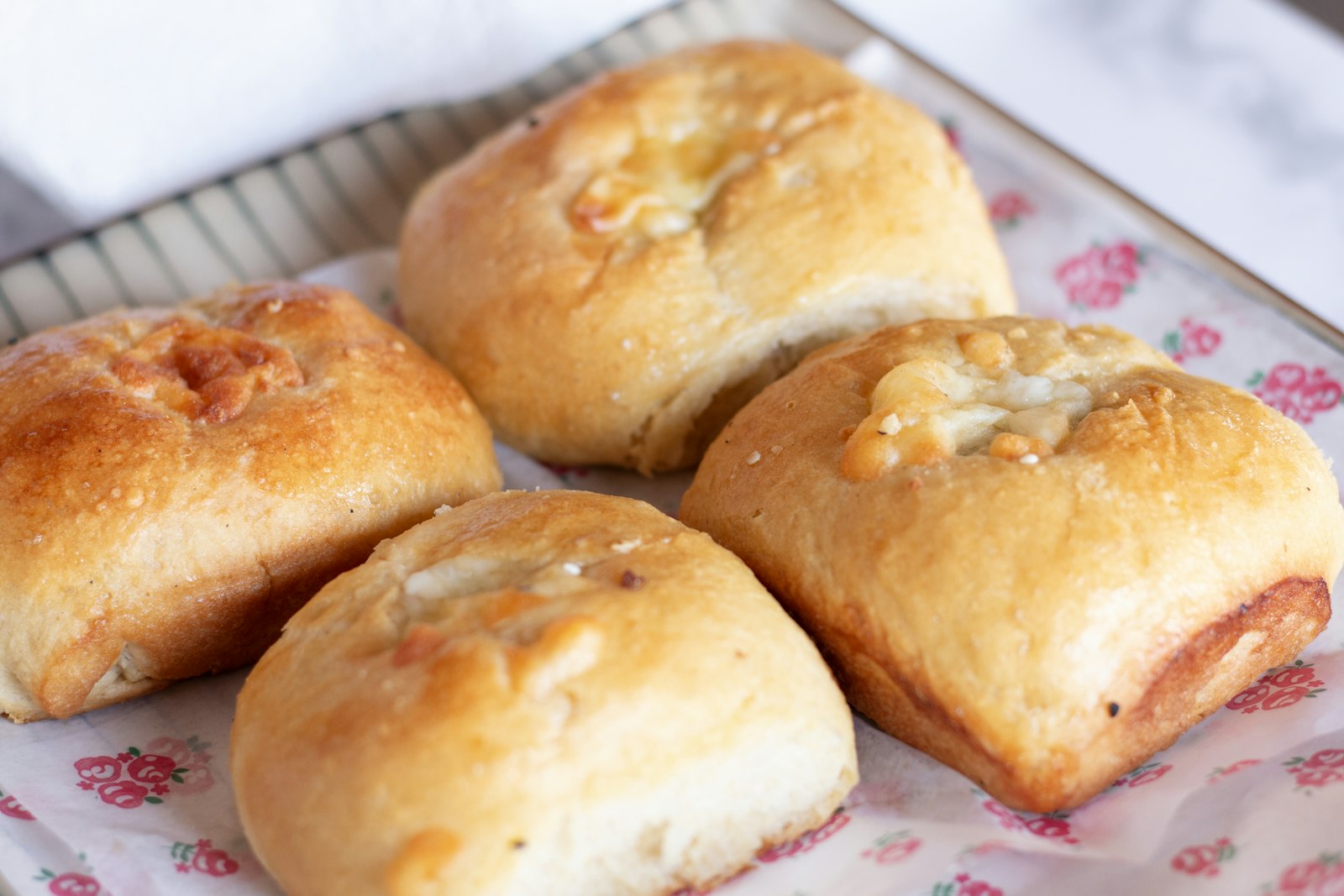 Four golden stuffed crescent pockets on a plate