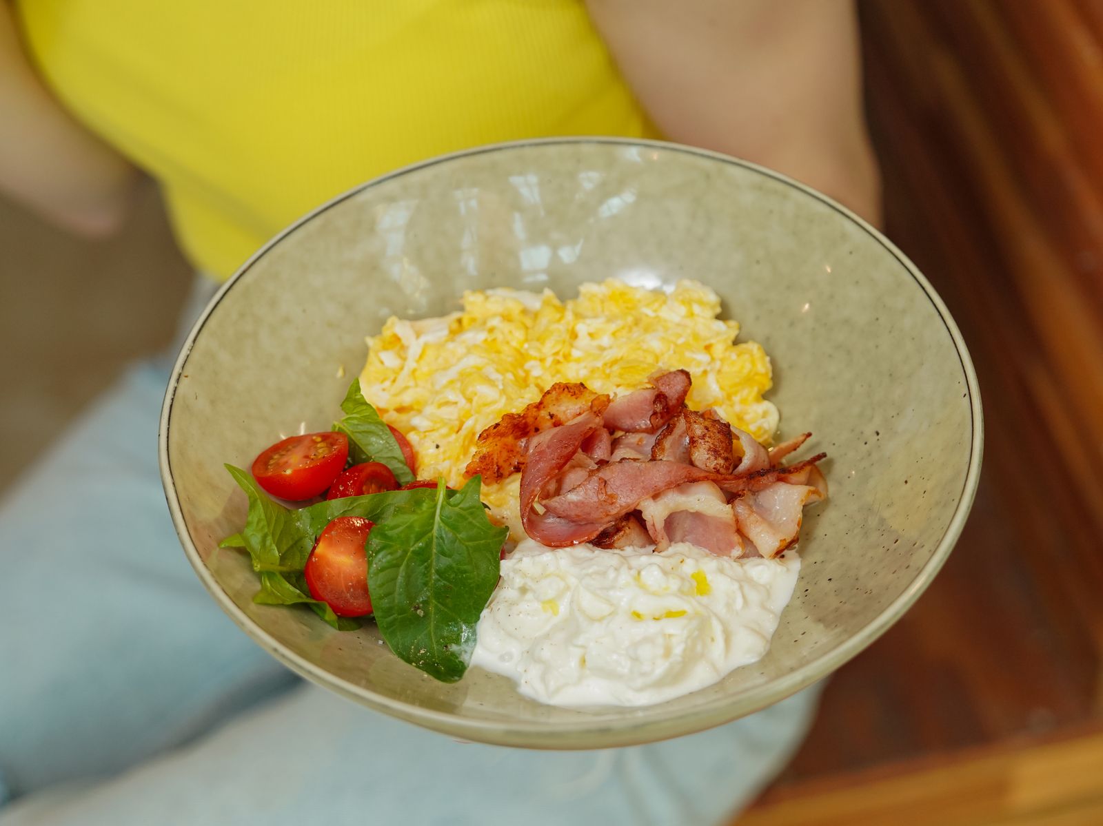 A bowl of scrambled eggs with diced ham and tomatoes