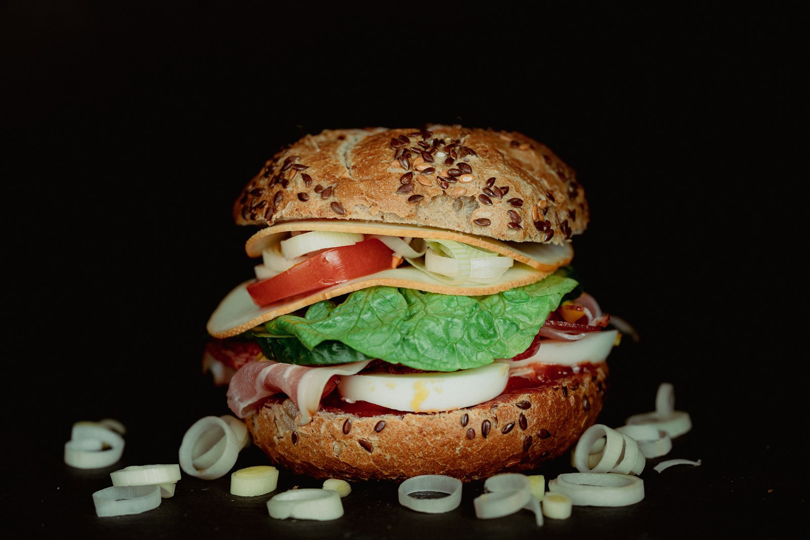 A stacked breakfast sandwich with lettuce, tomato and cheese
