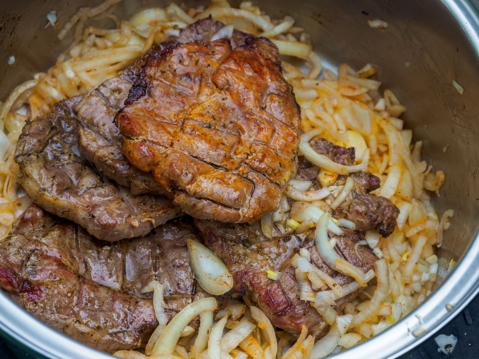 Steaks cooked down with onions in a pot