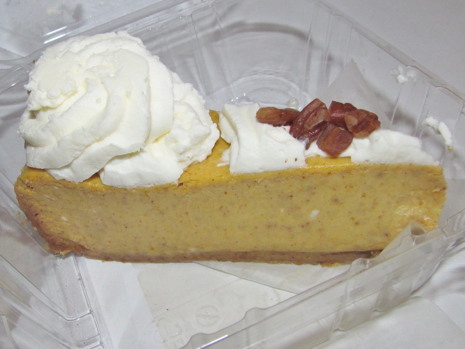 A slice of pumpkin cheesecake with whipped cream