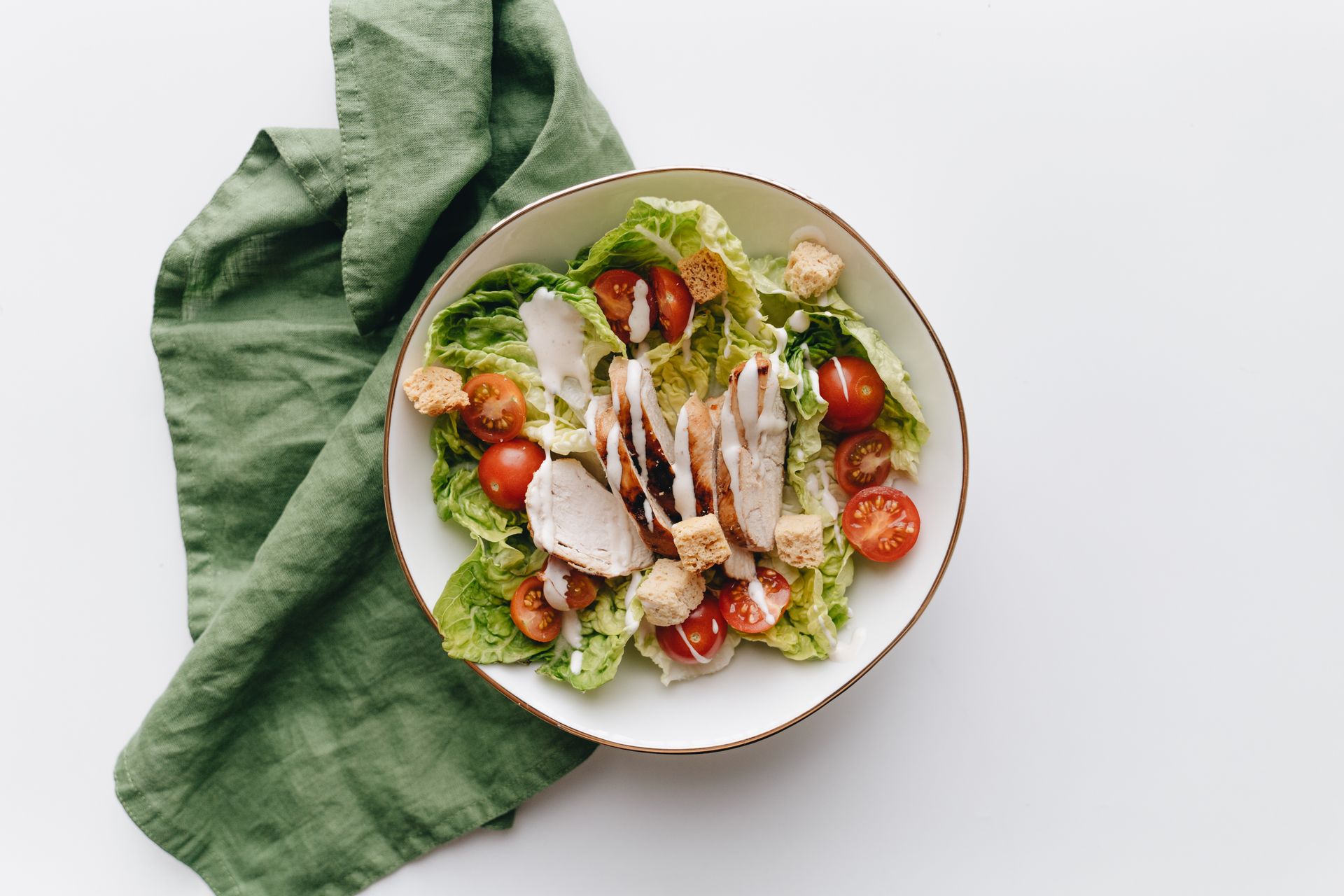 A bowl of chicken salad with fresh vegetables