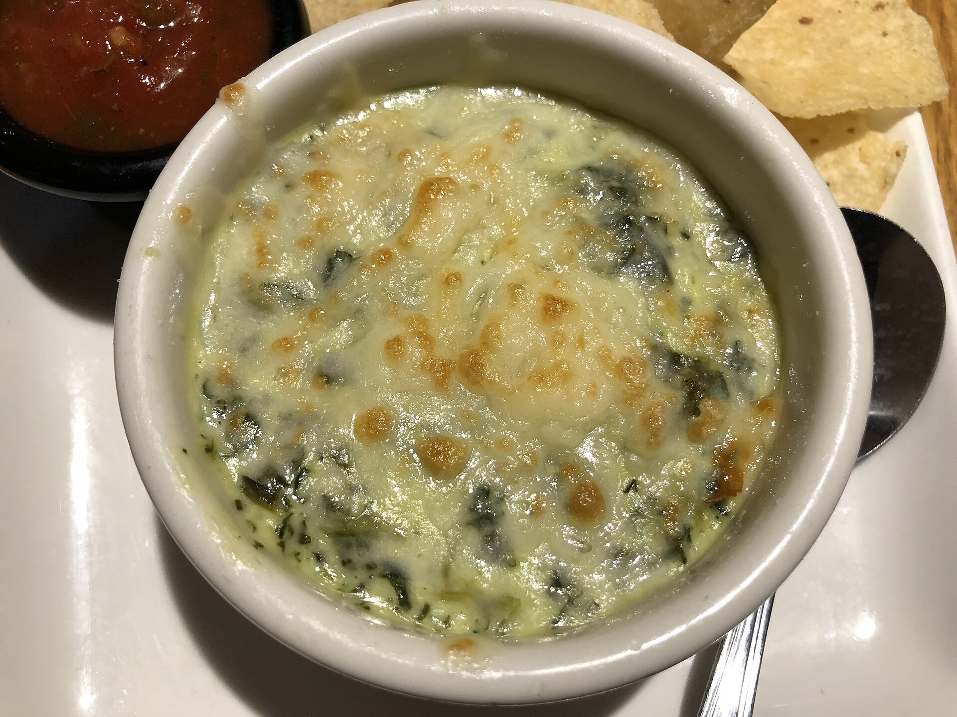 A bowl of hot spinach artichoke dip