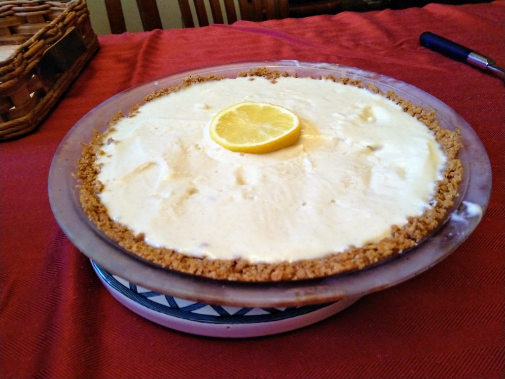 Whole lemon icebox pie with whipped topping and a lemon slice