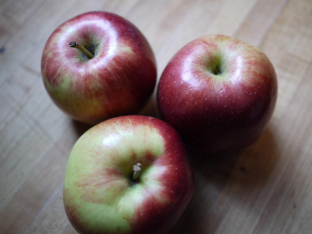 Firm red fruit for baking on a wooden counter