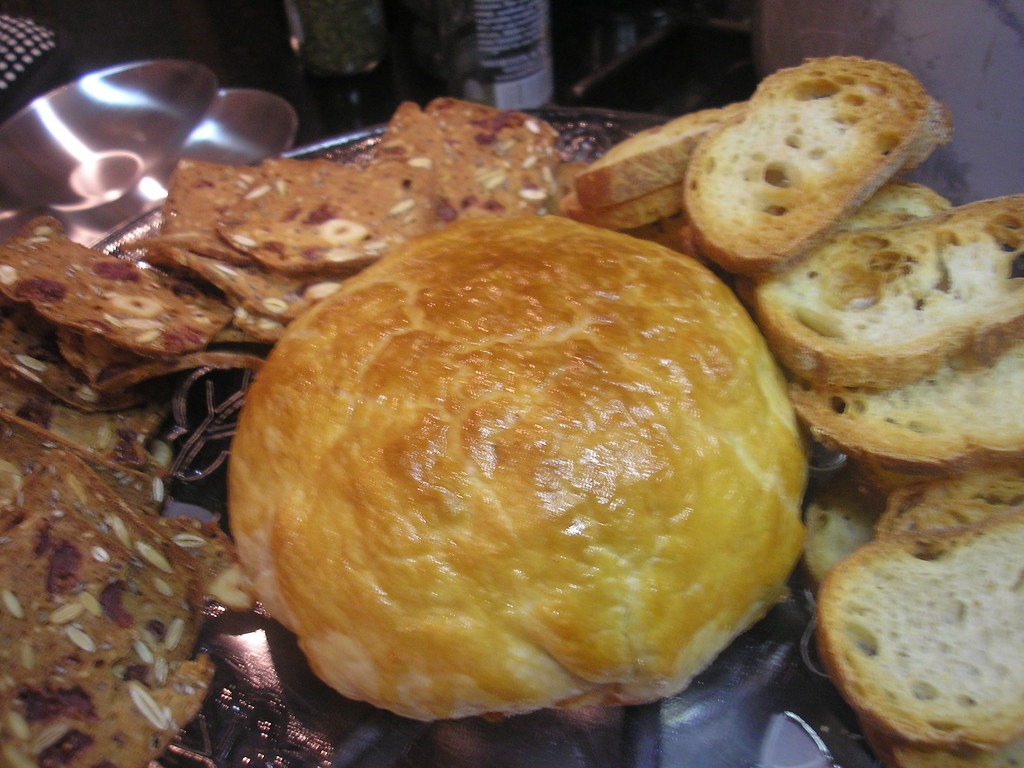 Classic baked brie en croute with toasted bread slices