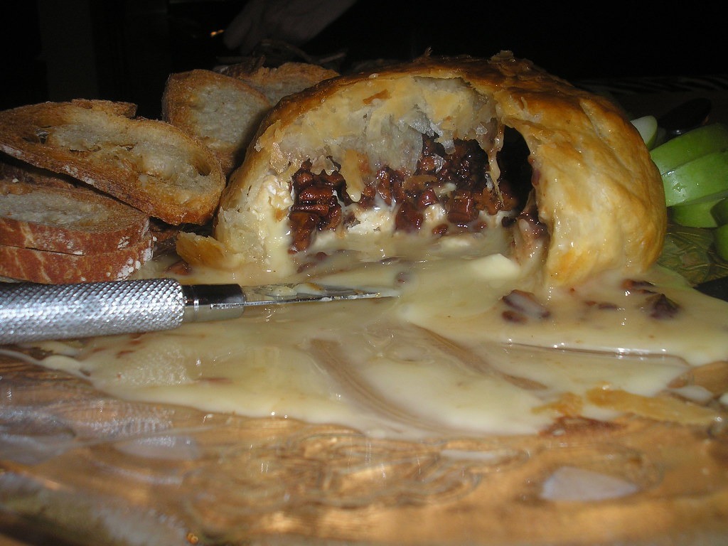 Cut brie en croute with a fig jam filling and melted cheese