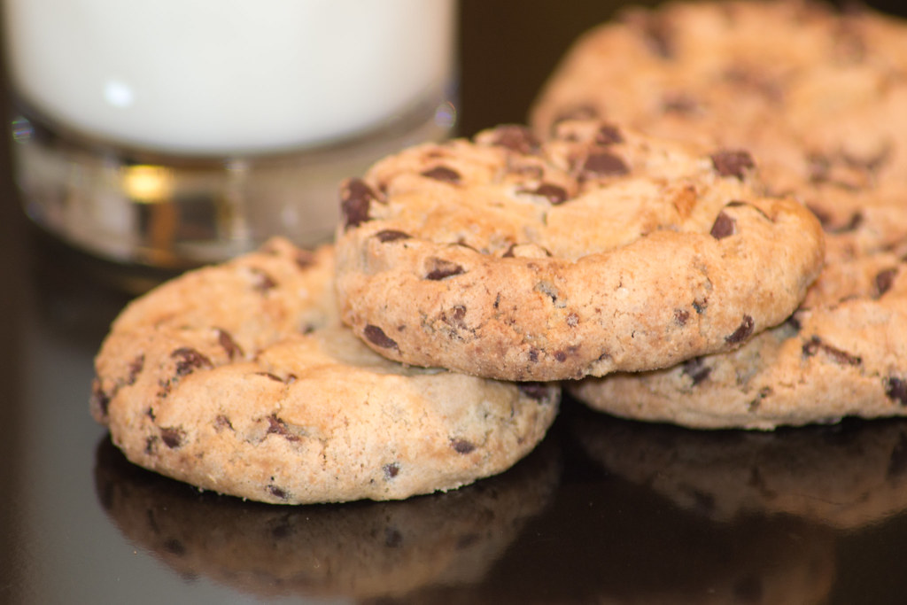 Thick chewy chocolate chip treats with a glass of milk