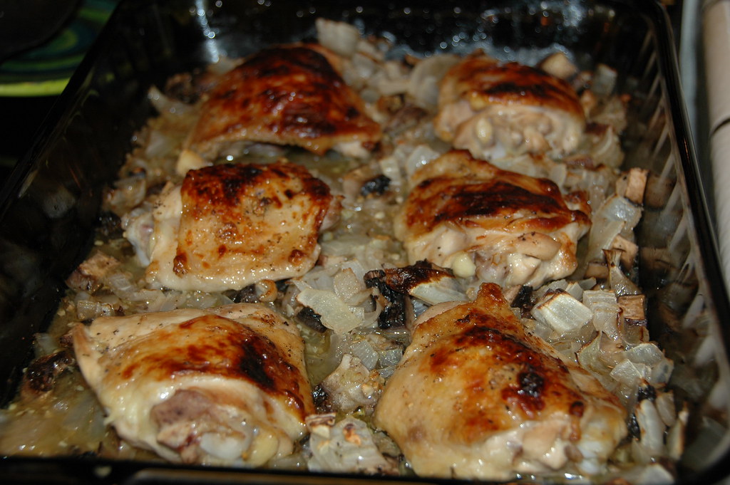 Baked chicken thighs with golden caramelized skin in a pan