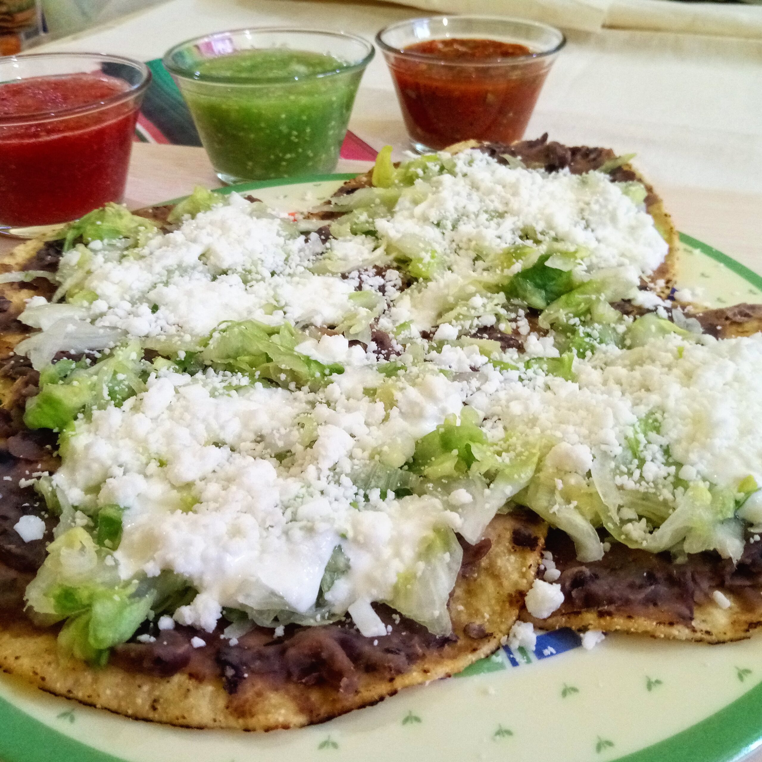 Crisp flat tostadas topped with refried beans and cheese, like Tex-Mex chalupas