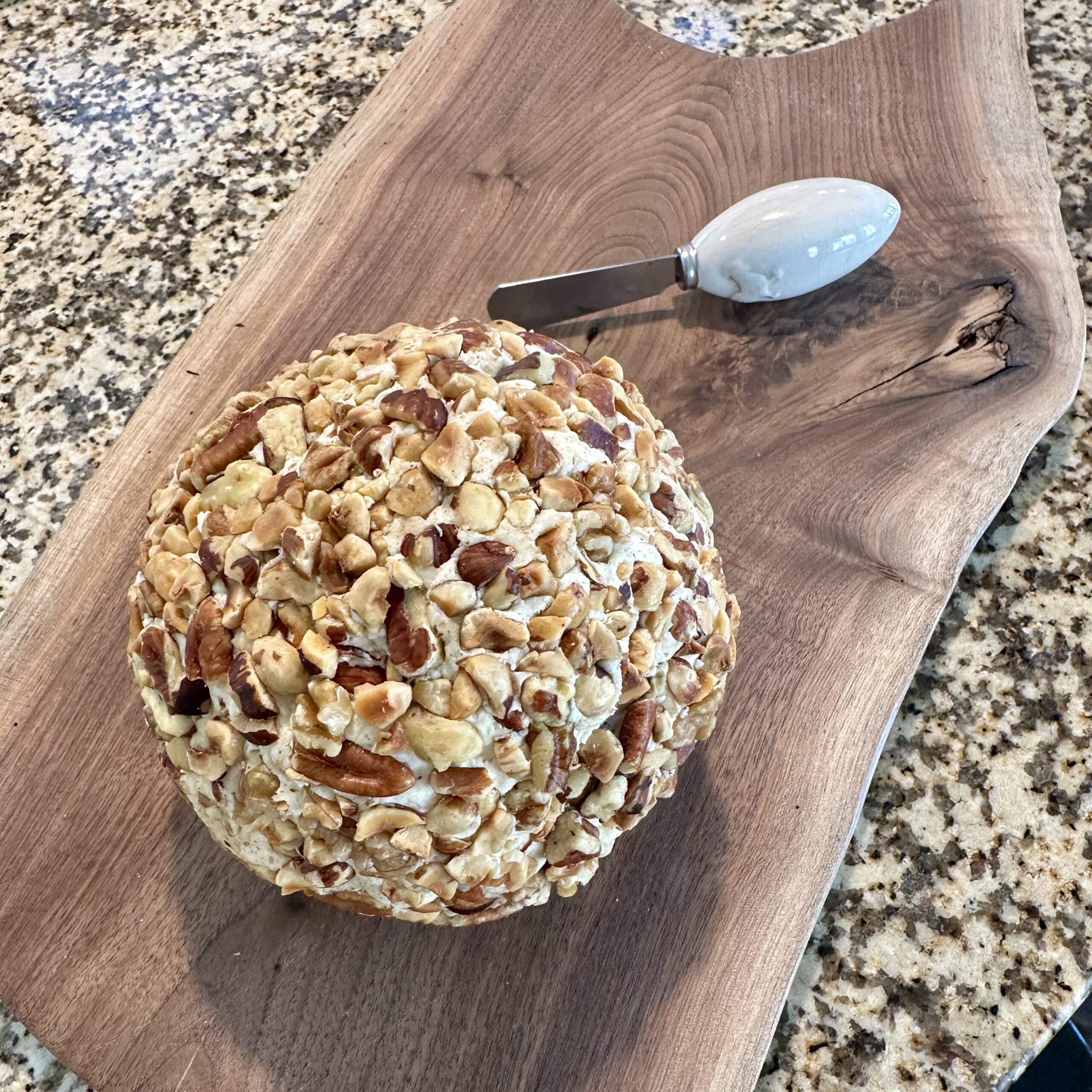 Pecan crusted pineapple party appetizer on a walnut board