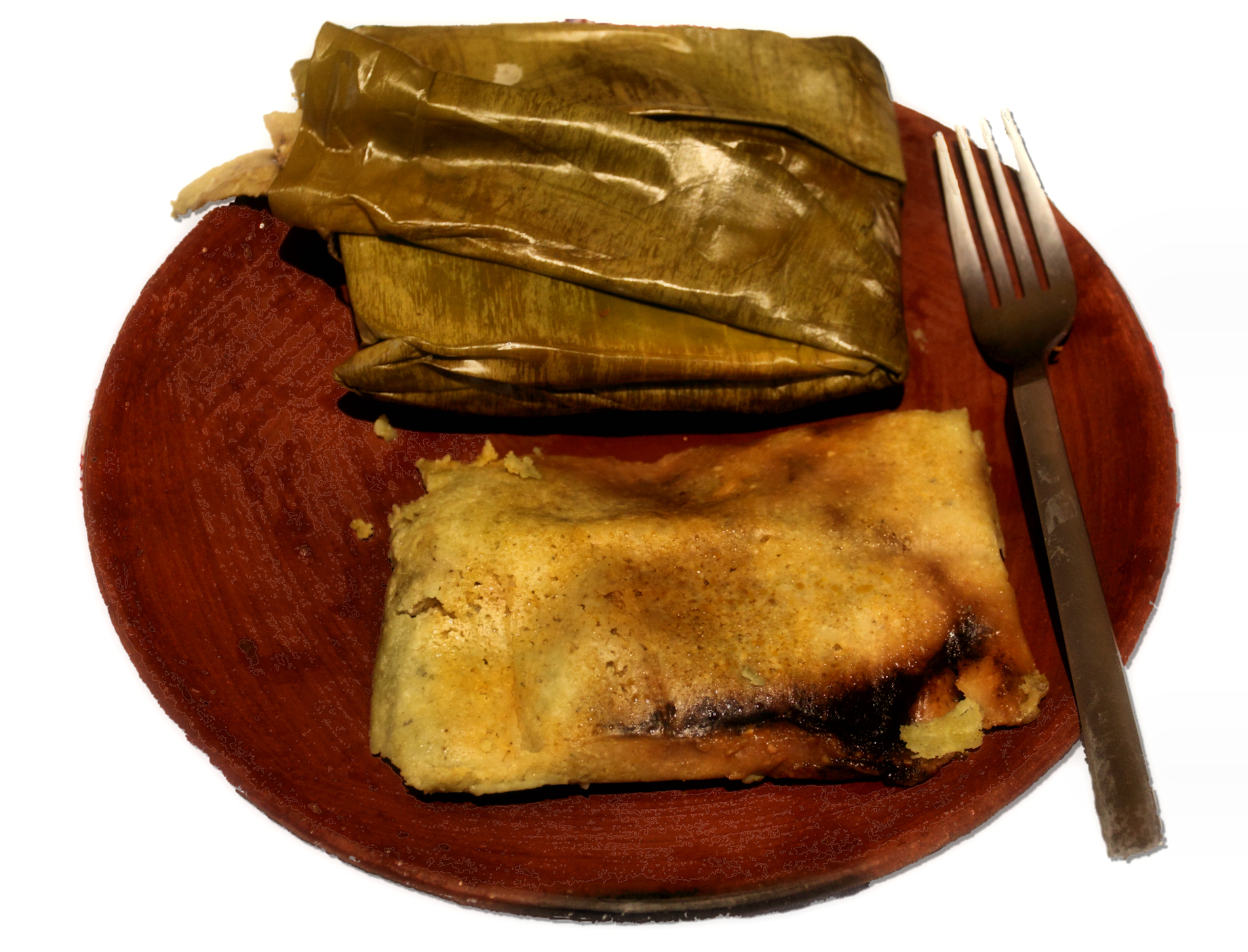 Oaxacan tamal wrapped in banana leaves on a plate