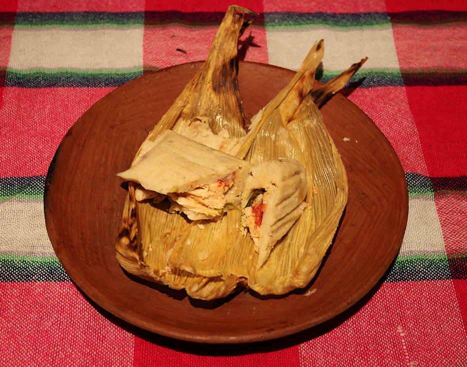Rajas con queso tamal unwrapped on a clay plate