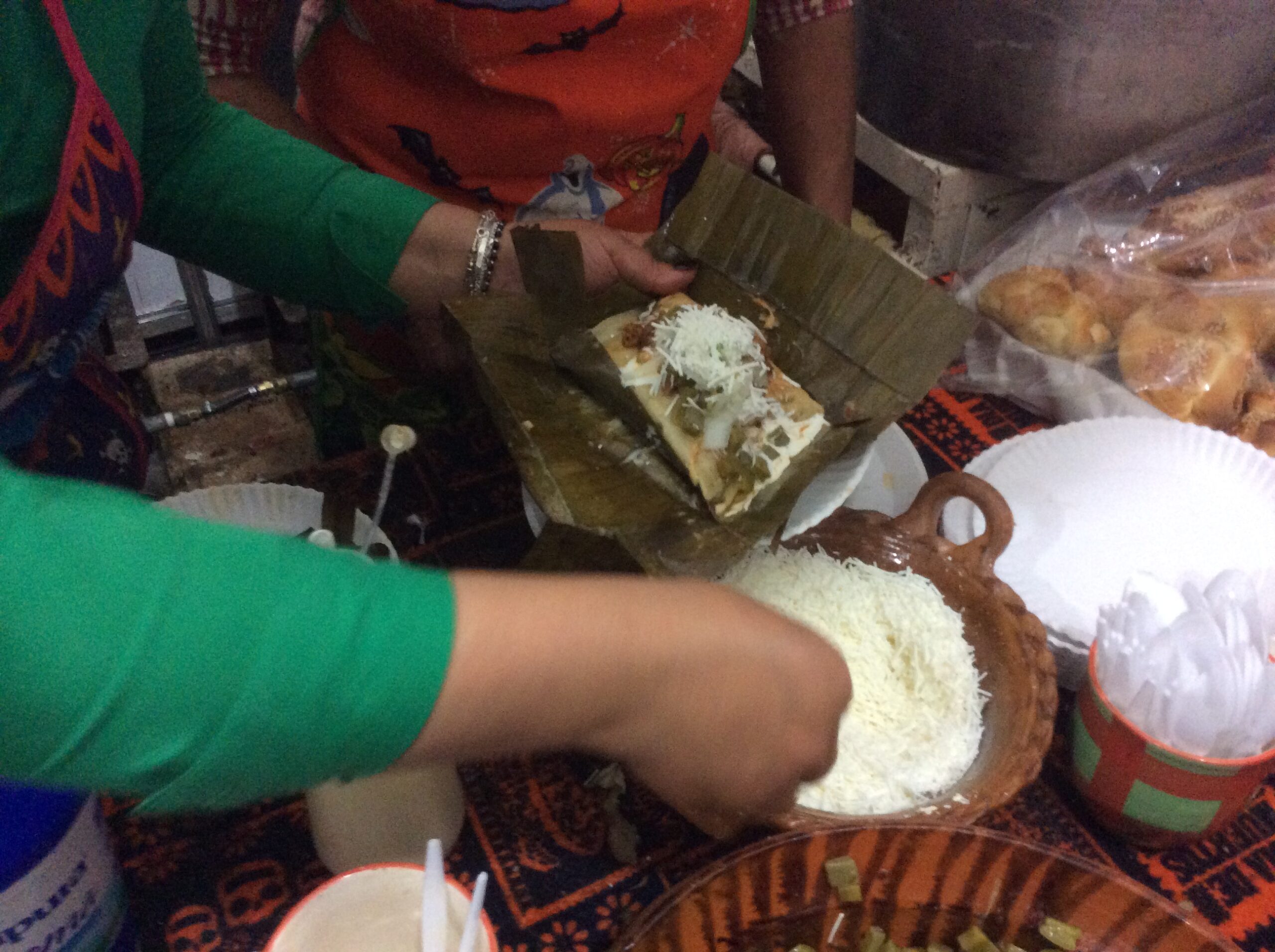 Masa being spread on a corn husk while making tamales