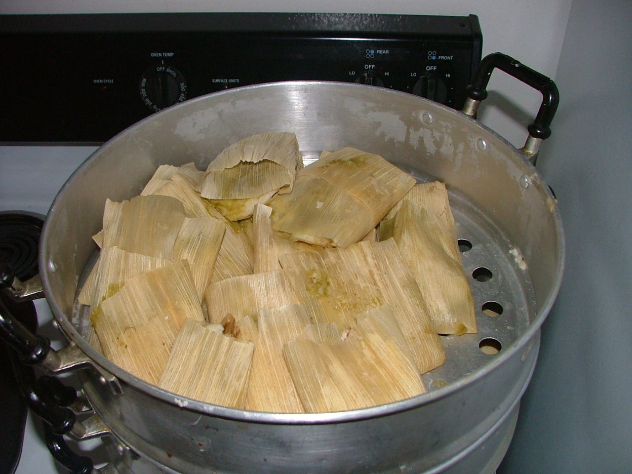 Christmas tamales standing upright in a steamer pot