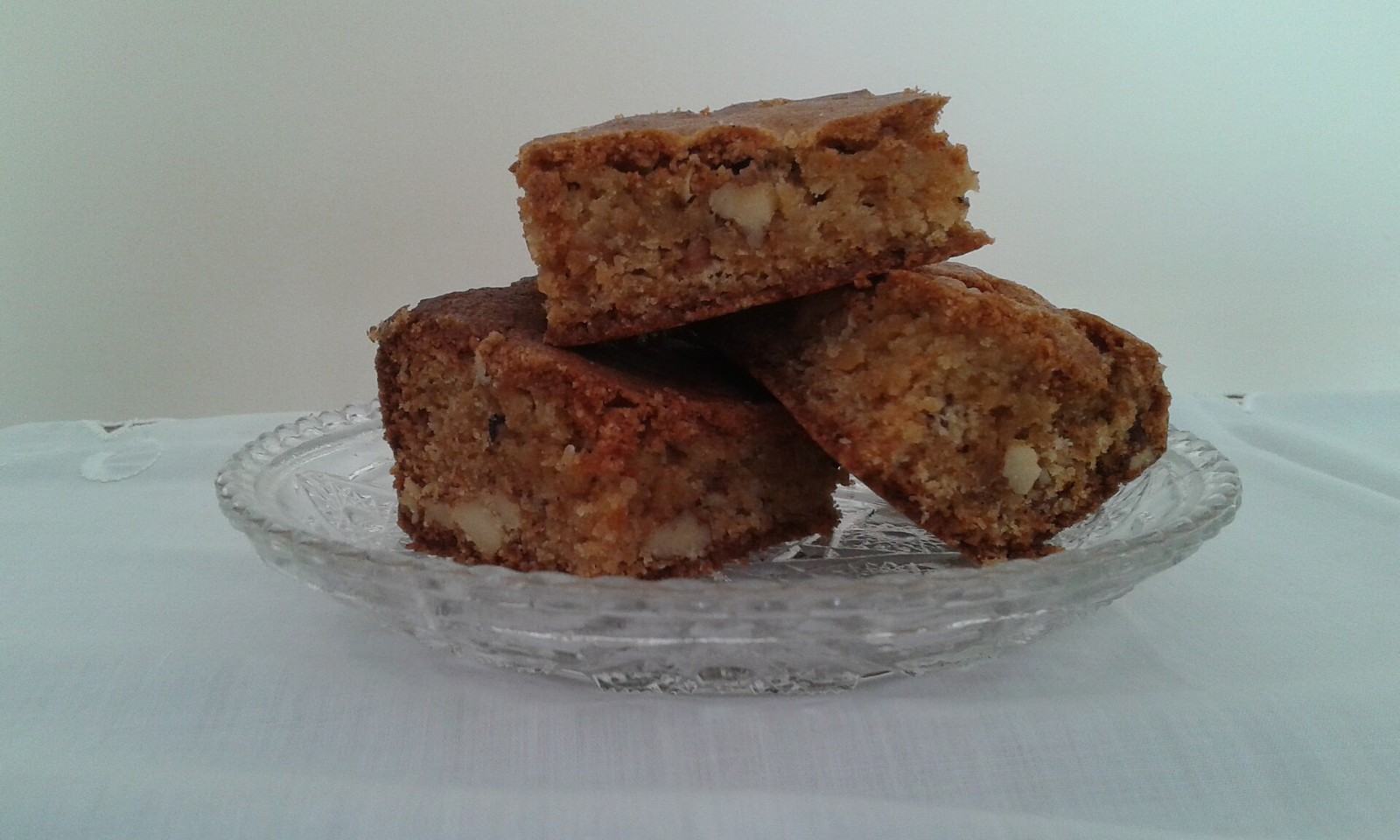 Chewy blondie squares stacked on a glass plate