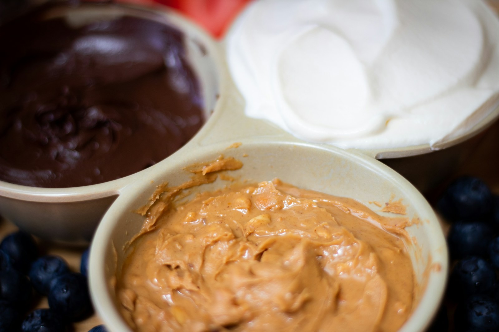 Bowls of creamy caramel-colored dip with berries for dipping