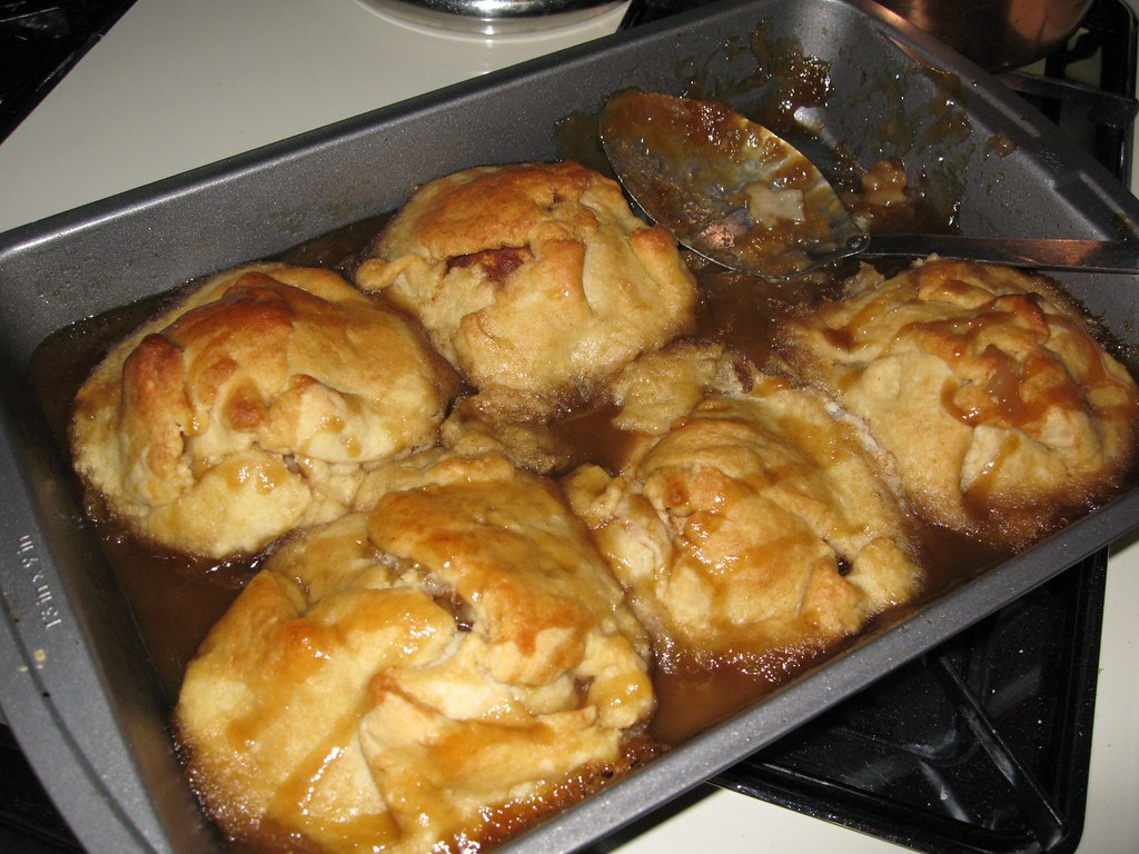Baked dumplings bubbling in cinnamon syrup in a pan