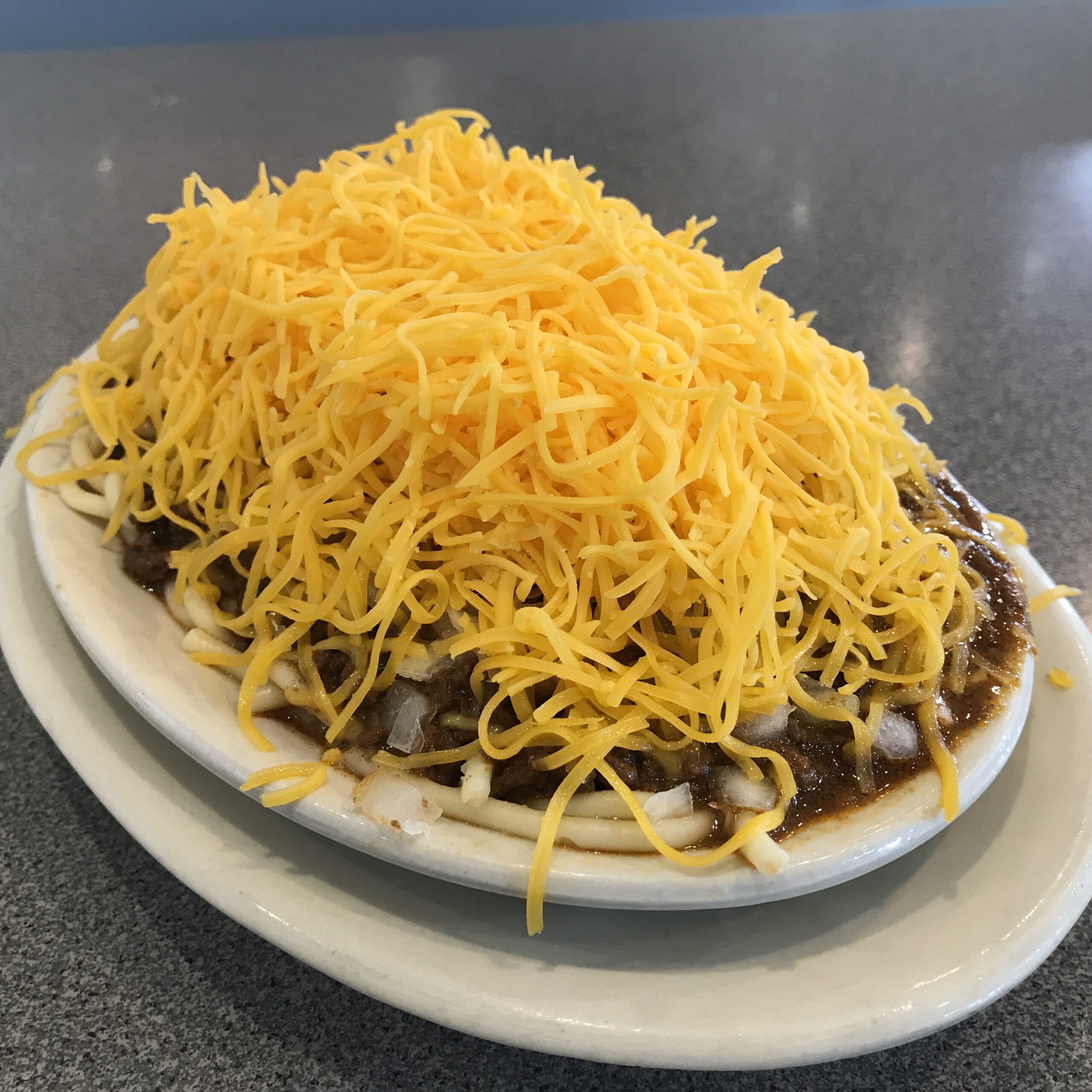 Cincinnati chili over spaghetti piled high with shredded cheddar