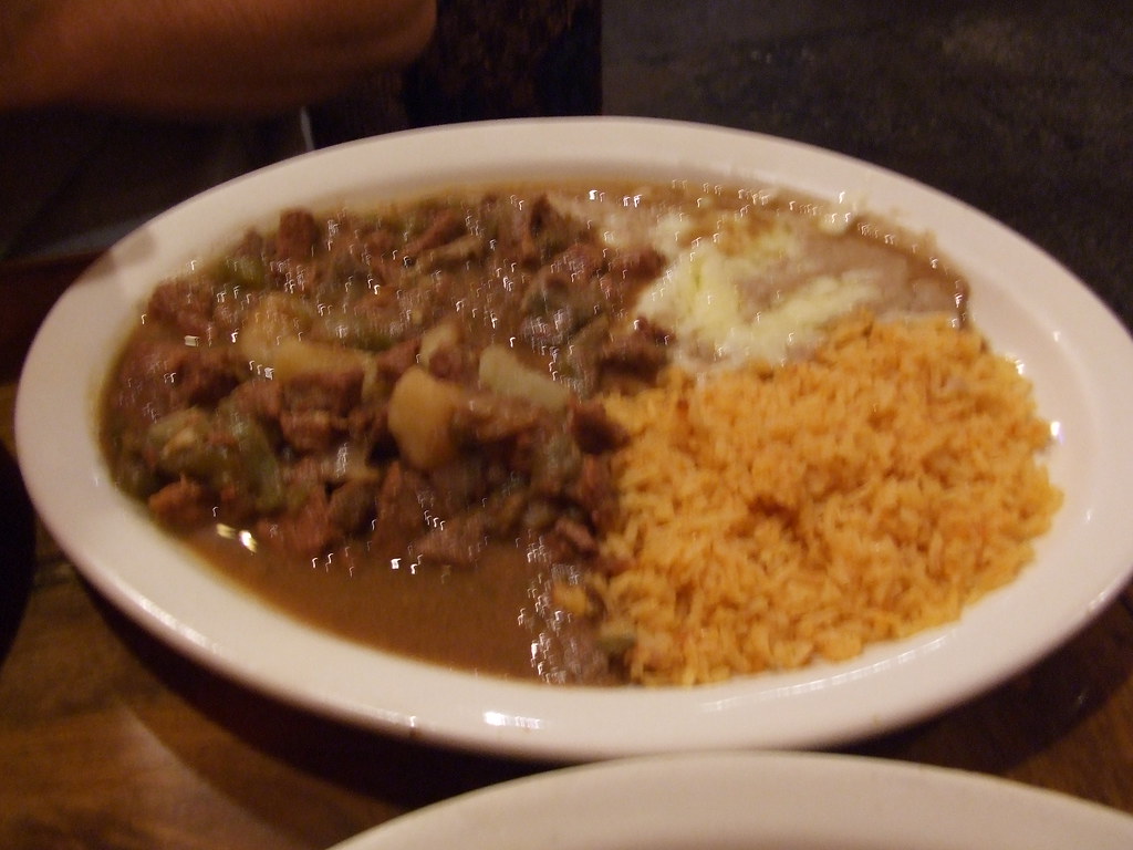 Plate of green chile verde with tender meat and rice