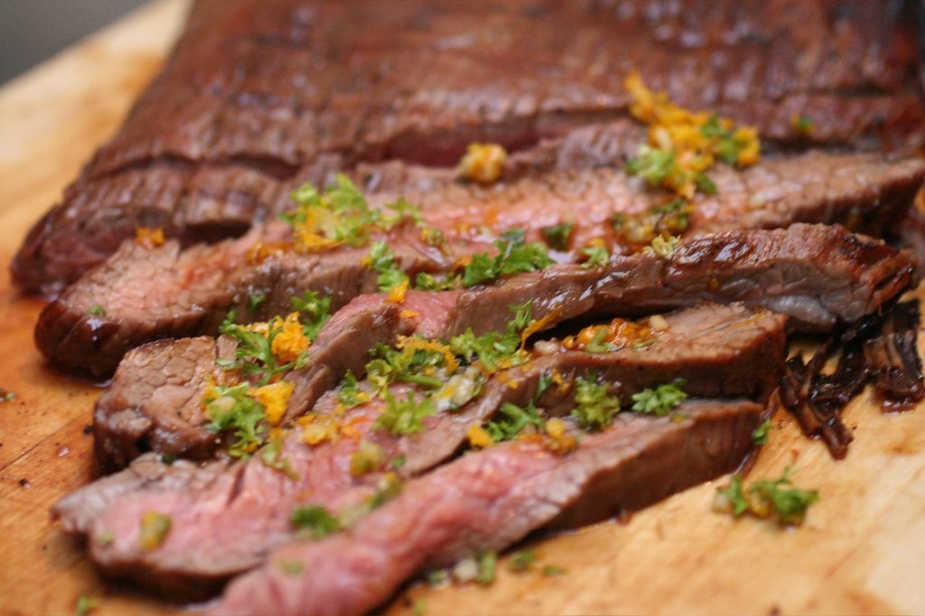 Sliced grilled flank steak on a cutting board