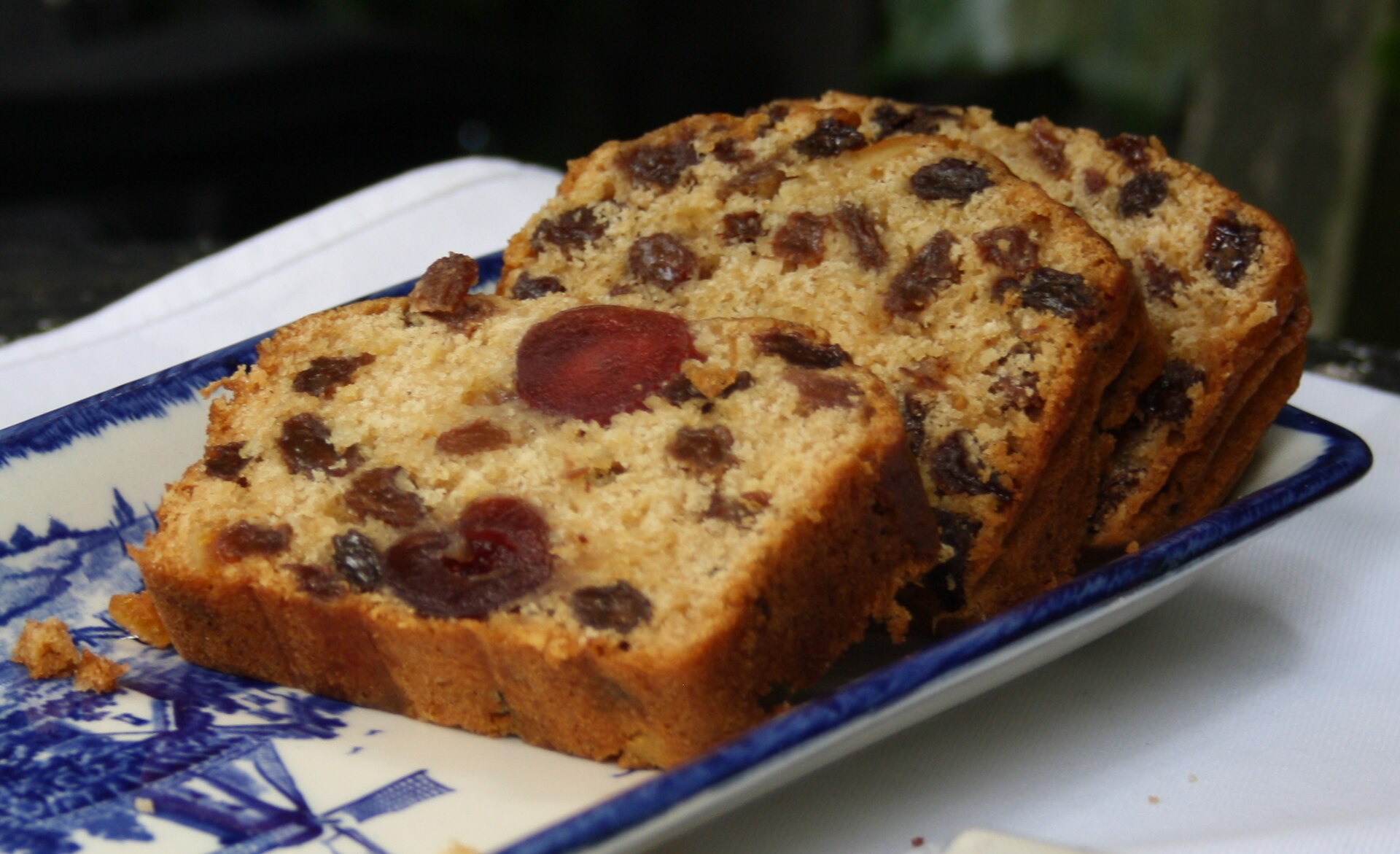 Slices of boiled fruitcake on a blue and white platter