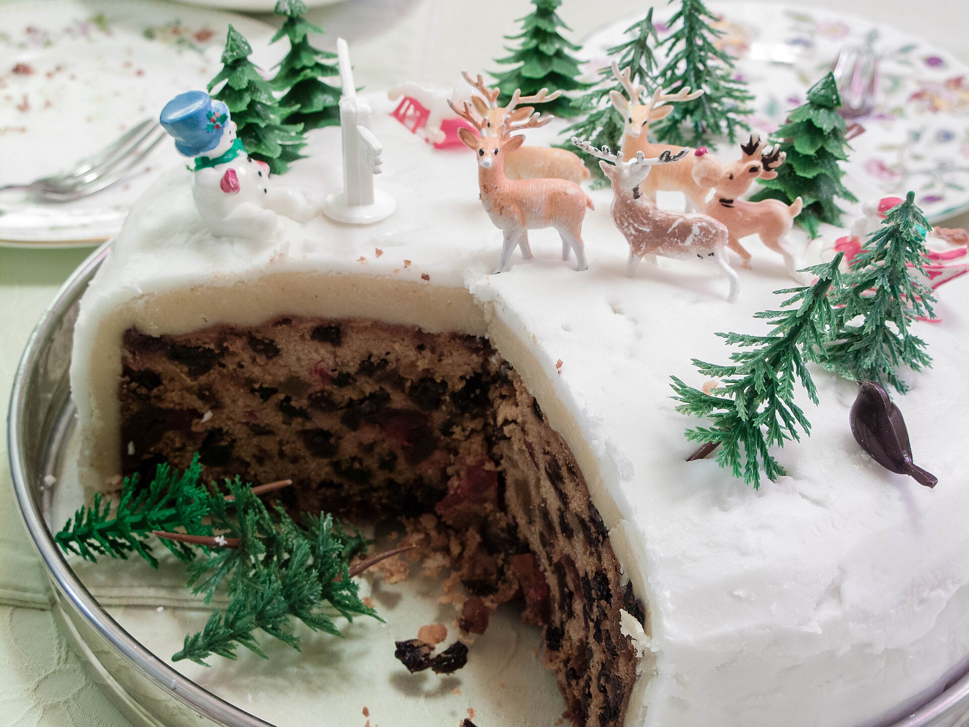 Iced Christmas cake cut open to show the dark fruit inside
