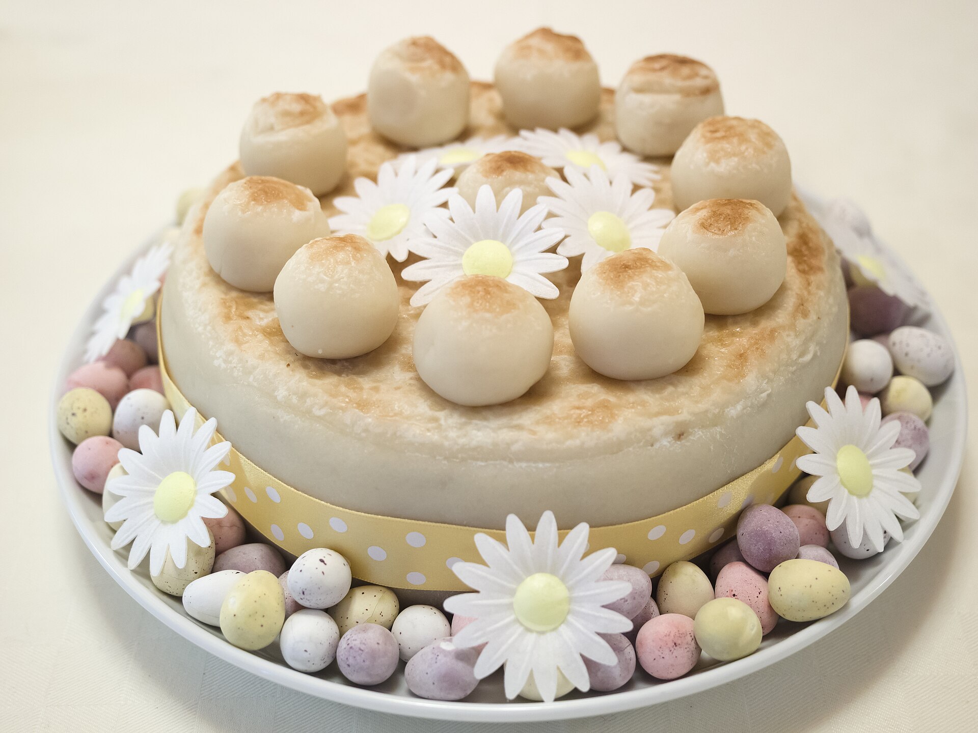 Easter simnel cake decorated with marzipan balls and flowers