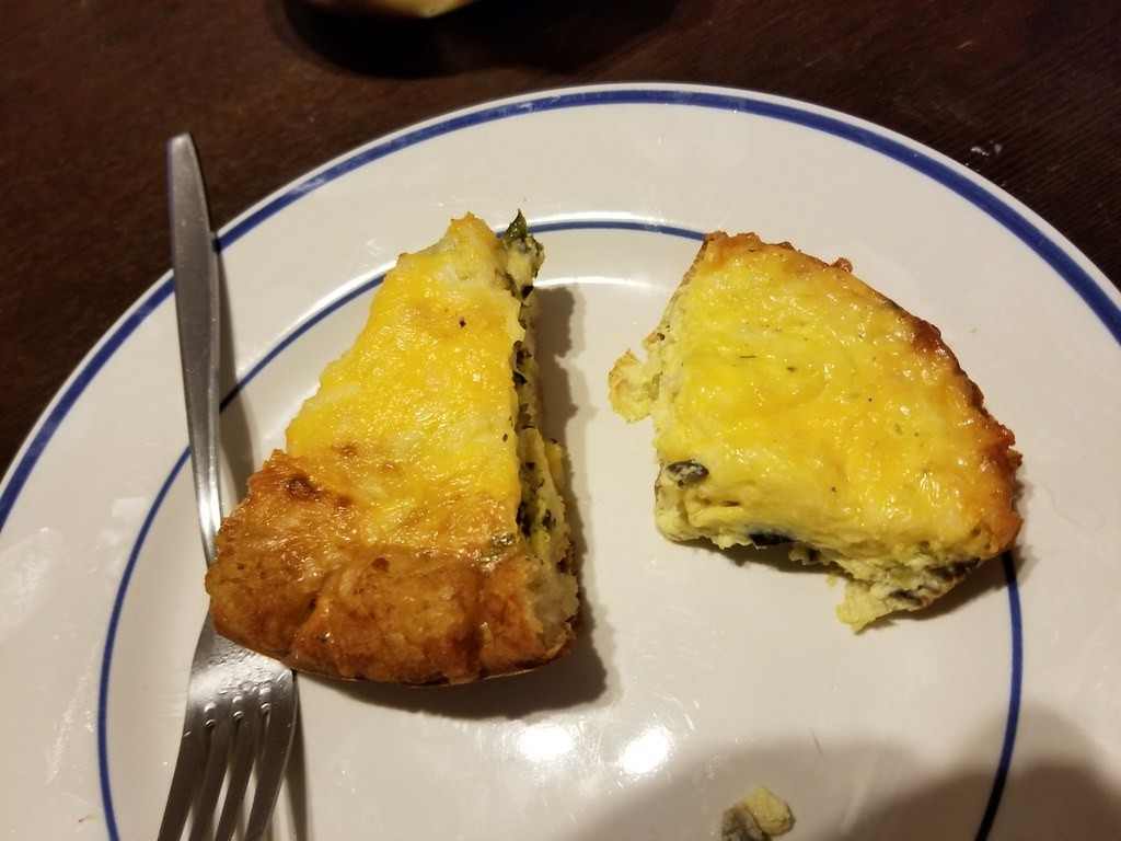 Slice of quiche with a crisp hash brown crust on a plate