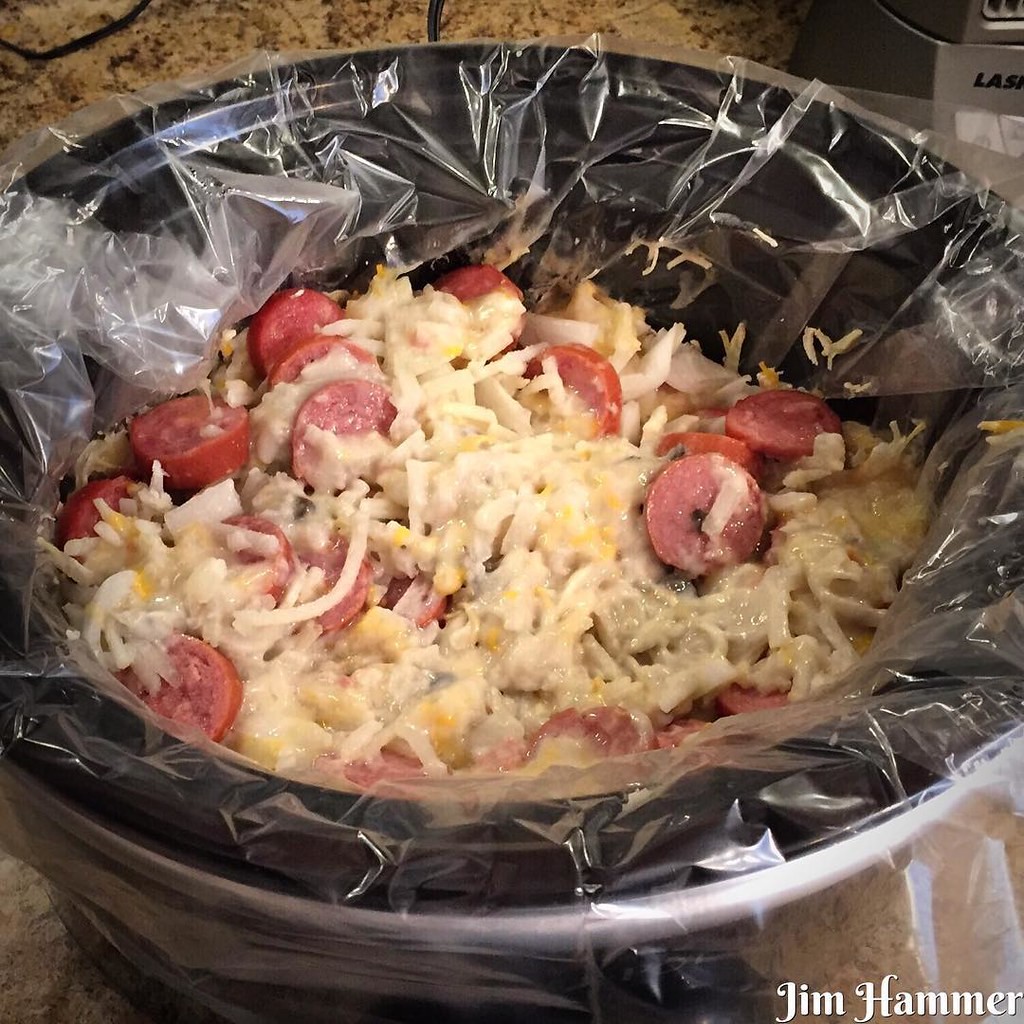Slow cooker filled with a creamy shredded potato and sliced kielbasa casserole