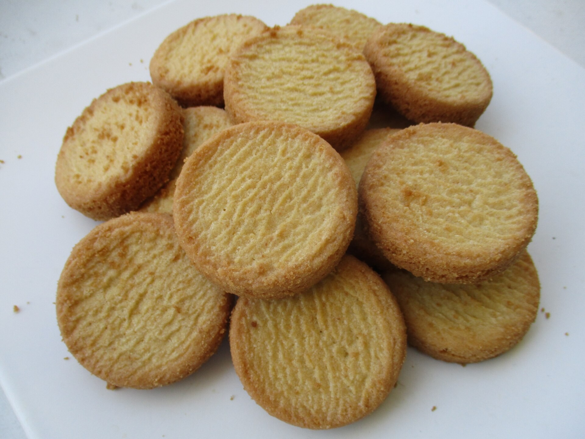 Golden Breton butter rounds piled on a white plate
