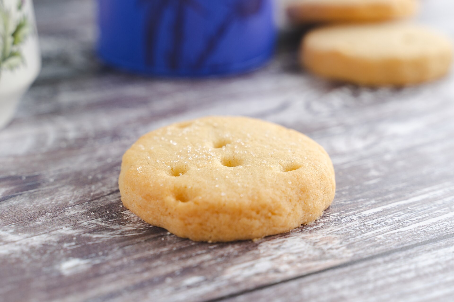 A single round butter shortbread on a rustic wooden table