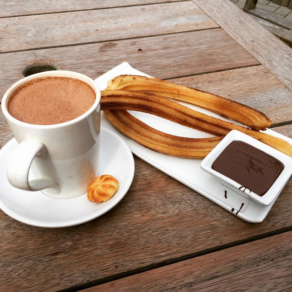 Churros with a cup of hot chocolate and chocolate dipping sauce