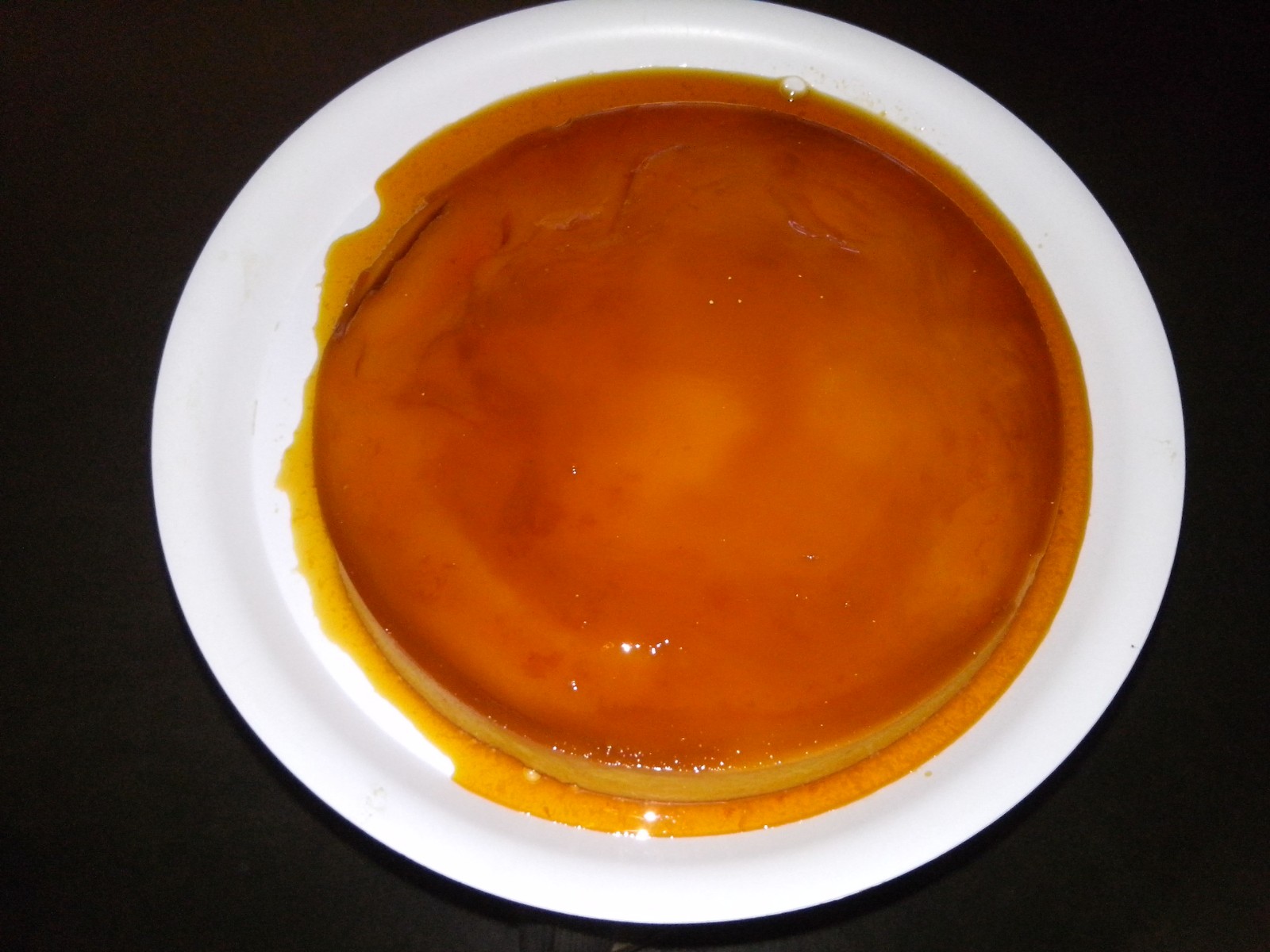 Mexican flan napolitano with caramel sauce on a white plate