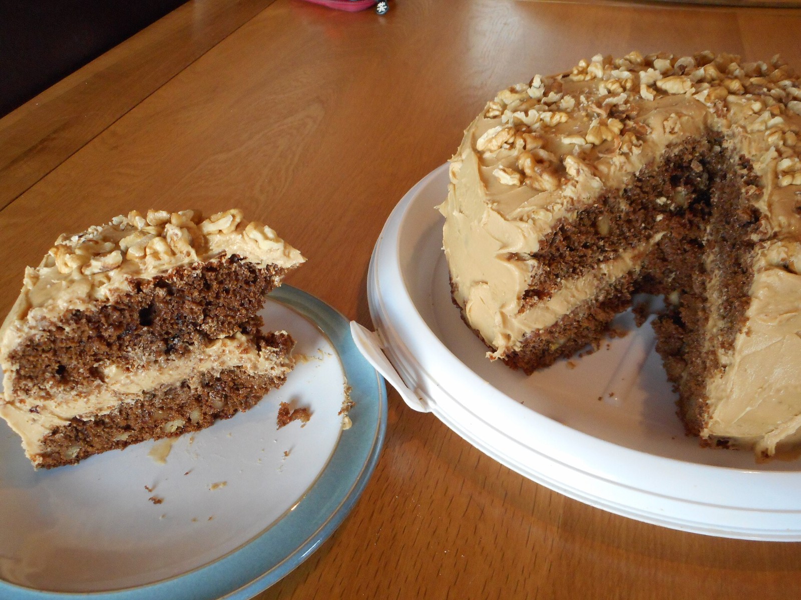 Coffee and walnut cake with a slice cut on a plate
