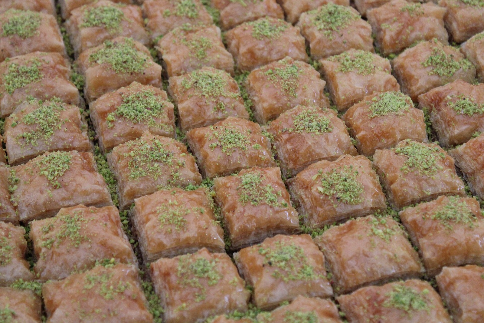 Tray of baklava squares topped with bright green ground pistachios