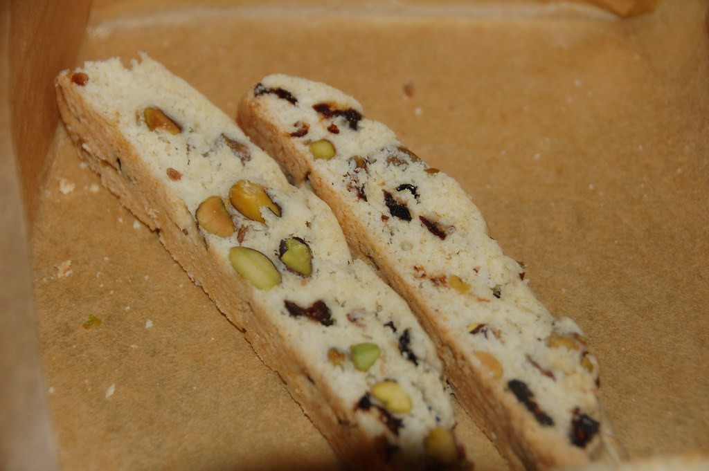 Sliced biscotti studded with green nuts and red dried cranberries