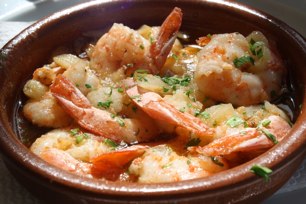 Gambas al ajillo garlic shrimp in a clay dish with parsley