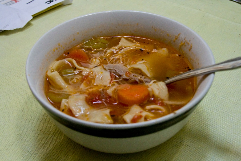 Bowl of homemade chicken noodle soup with carrots and celery