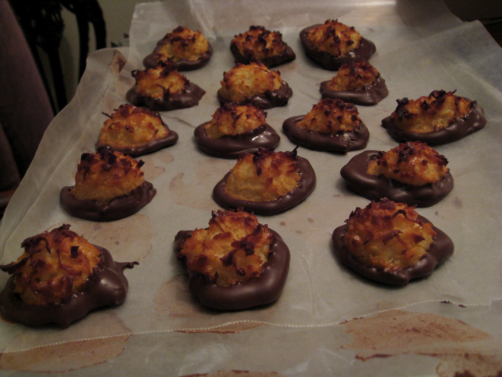Macaroons with dark chocolate dipped bottoms on parchment paper