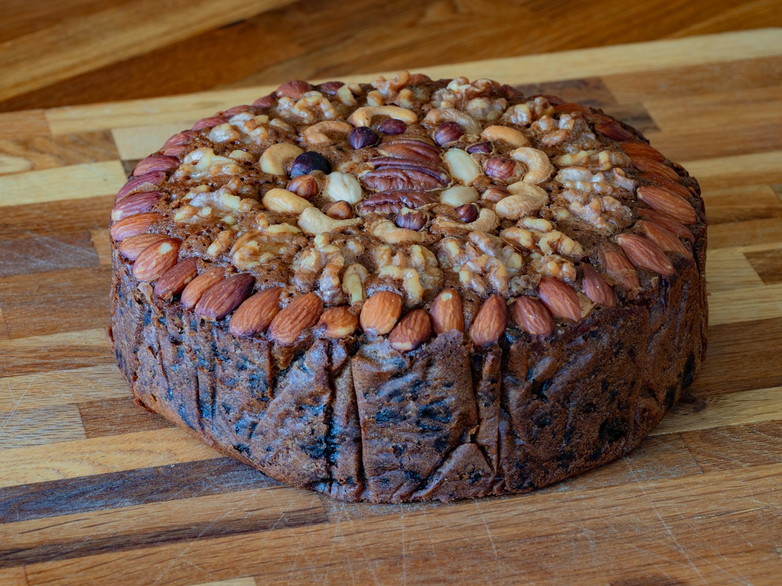 Round Christmas fruitcake topped with rows of whole nuts