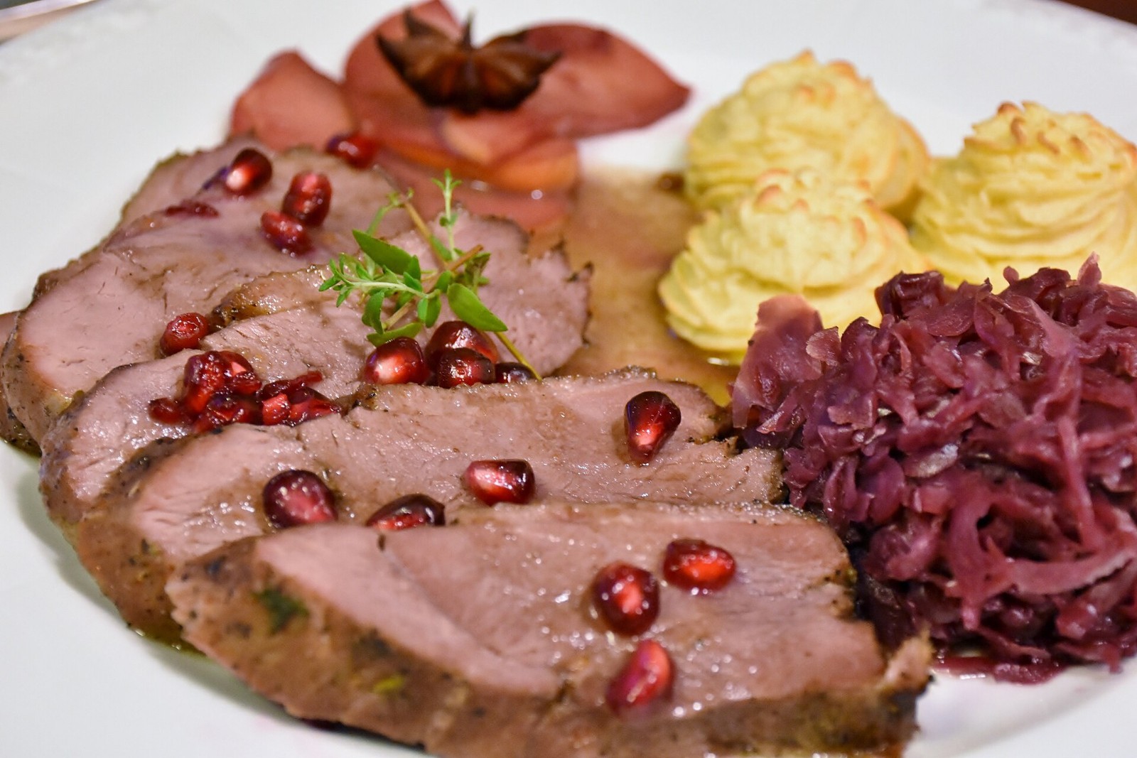Sliced roast Christmas goose with red cabbage on a holiday plate