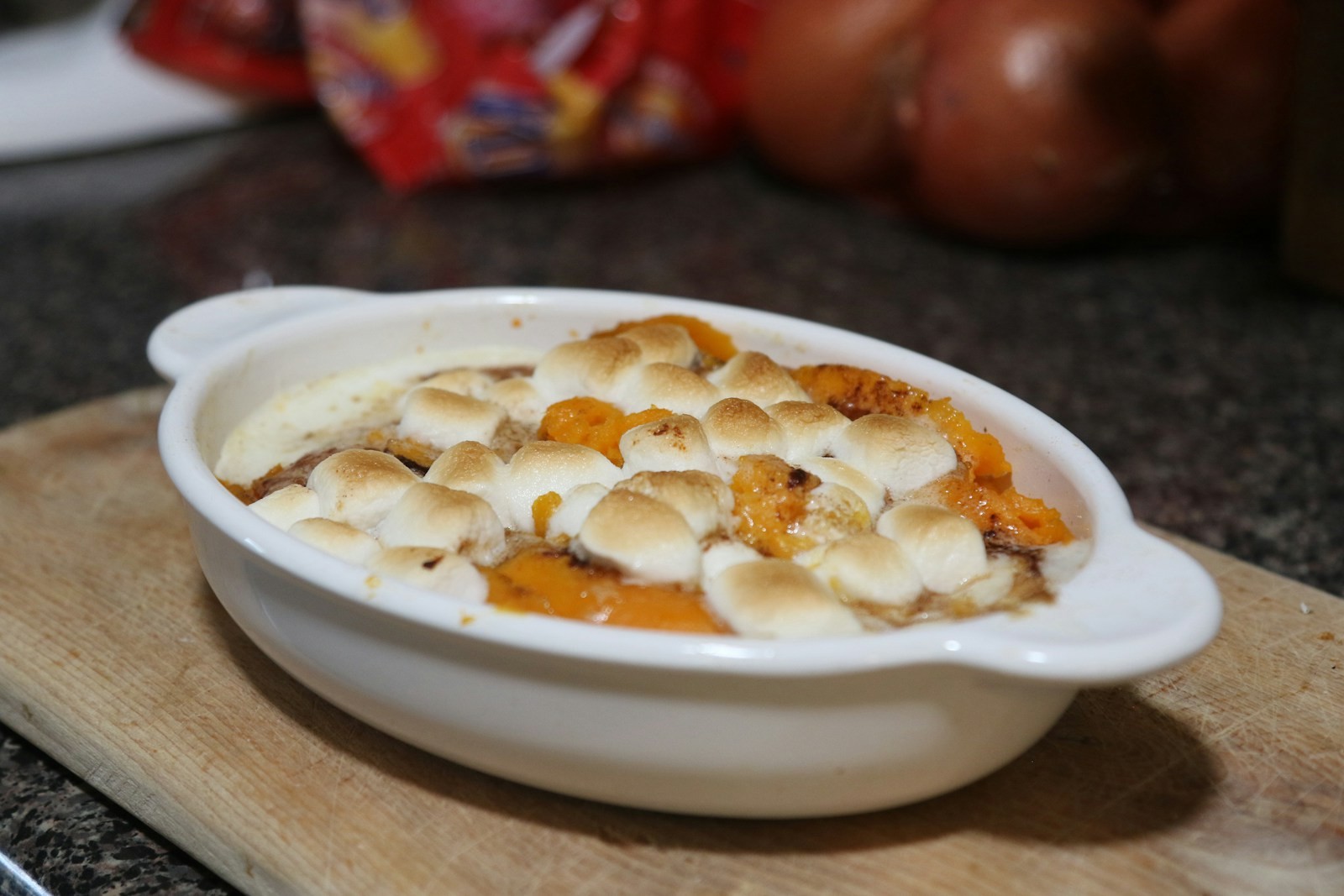 Sweet potato casserole topped with toasted golden marshmallows in a baking dish