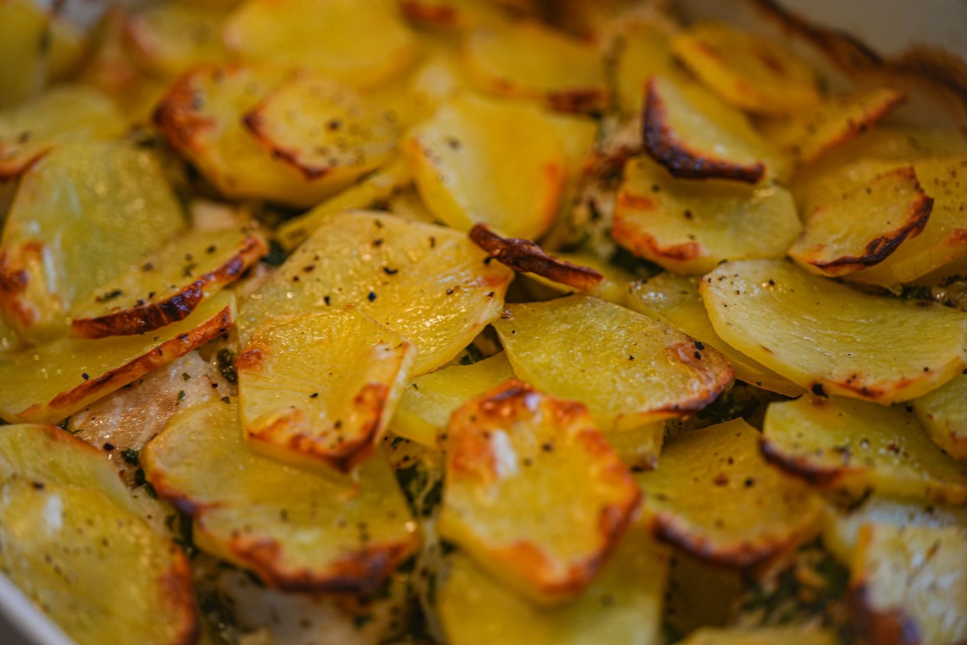 Crispy roasted potato slices with herbs and black pepper