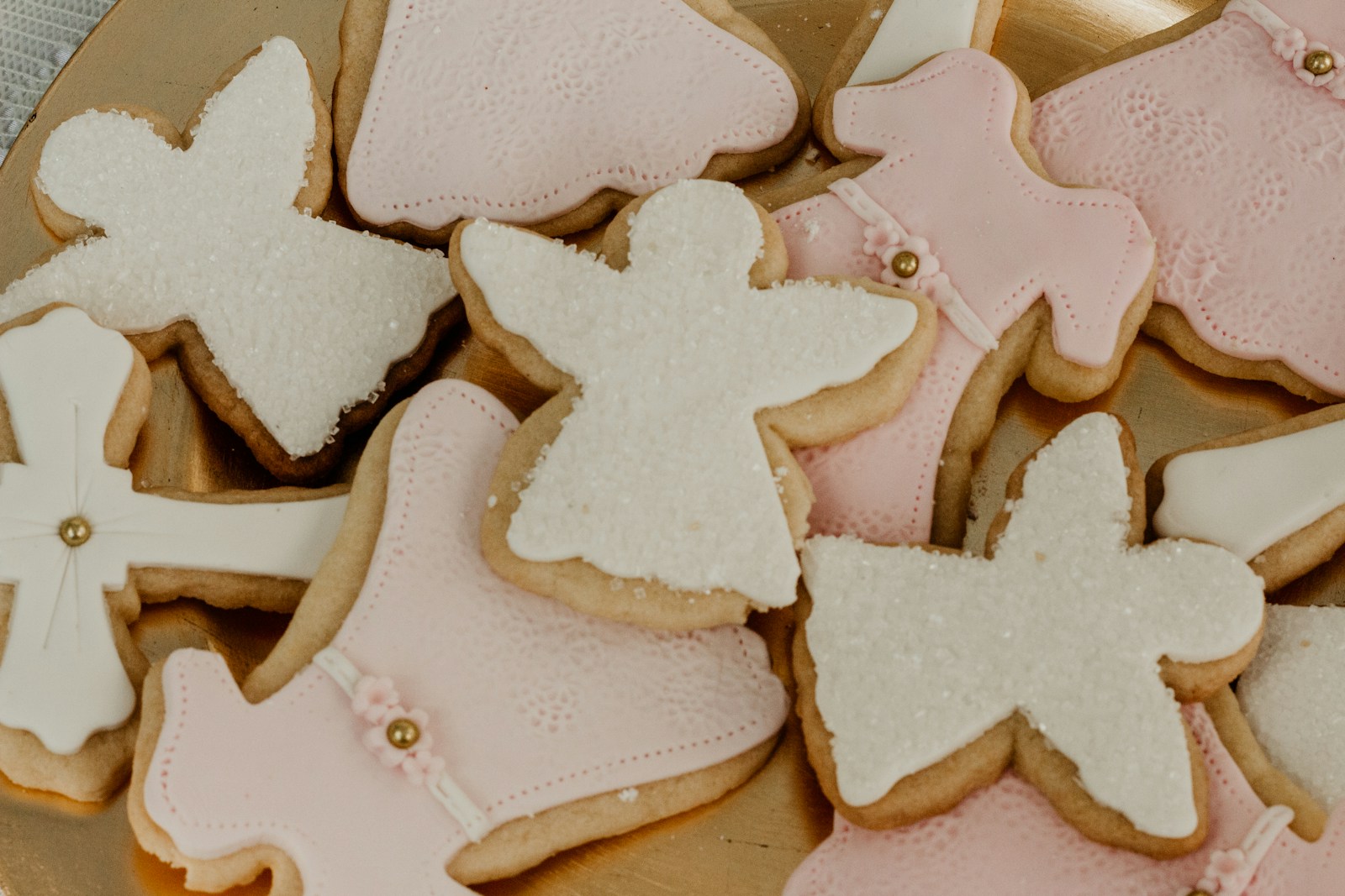 Angel and star shaped cut-outs with white and pale pink glaze and coarse sparkles